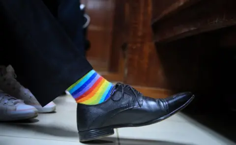 EPA A Kenyan LGBT activist wears rainbow socks as he and his friends wait for a court ruling on an anti-homosexual law at a court in Nairobi, Kenya, 22 February 2019