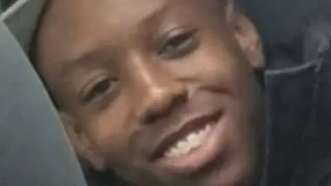 Met Police Image of Renell Charles wearing a hat and smiling.