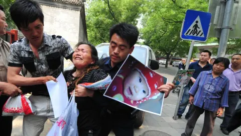 Getty Images A woman who granddaughter died in the 2008 milk scandal protests in Beijing