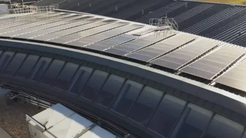 The roof is covered in solar panels to reduce reliance on the electricity grid