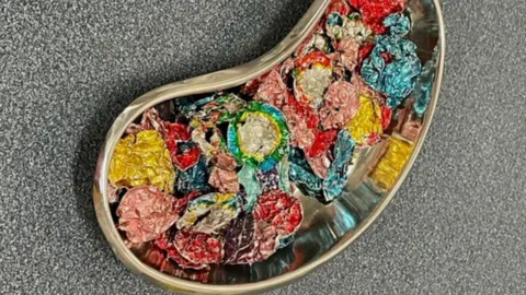 PA/PDSA Foil coin wrappers in a surgical dish