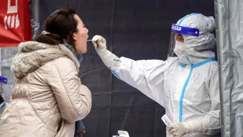 Getty Images A resident undergoes a nucleic acid test for the Covid-19 coronavirus in Xi'an in China's northern Shaanxi province on December 30, 2021.