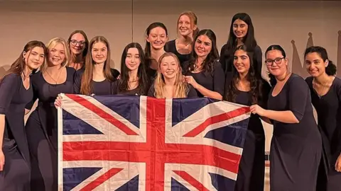 Interkultur/Studi43 Amabile choir from Merchant Taylors' School holding a Union Jack flag