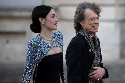 Getty Images Mick Jagger and his partner US choreographer Melanie Hamrick arrive to attend a state banquet at the Palace of Versailles