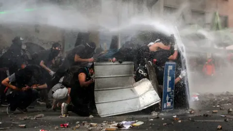 AFP Demonstrators clash with riot police during a protest demanding greater social reform on 12 November, 2019.