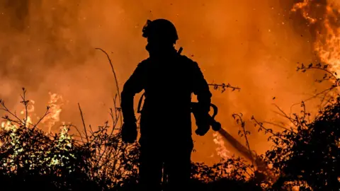 AFP via Getty Images A firefighter tackles a fire in northern Portugal. Photo: July 2022