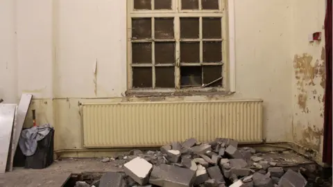 Boarded up windows inside Cefn Fforest Miners Institute