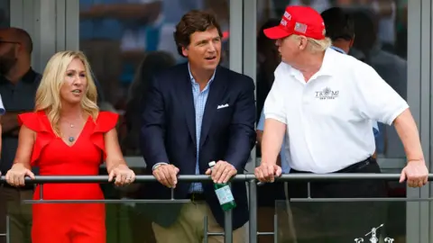 Getty Images Tucker Carlson, Marjorie Taylor Greene, Donald Trump