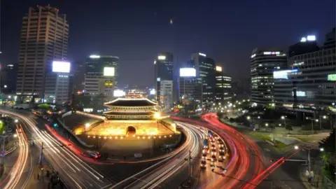 Getty Images Traffic commuting at night near South Korea"s landmark Namdaemun gate in Seoul