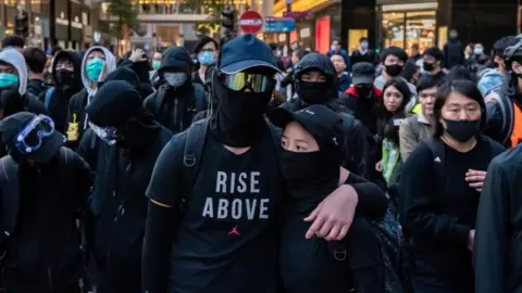 Getty Images Protesters form a frontline during a stand-off with police at the demonstration