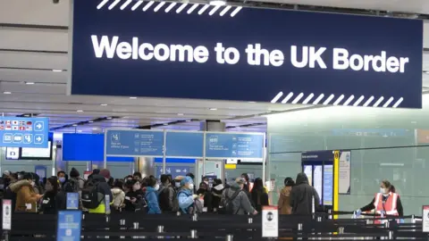 People queueing at passport control at Heathrow Airport