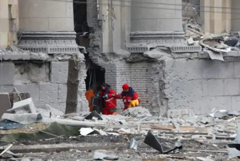 Reuters Rescuers dig through rubble after shelling of the state office in Kharkiv