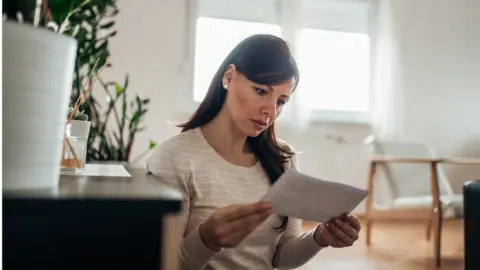 Getty Images A woman reads a letter