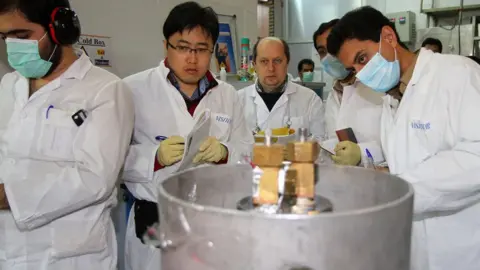 AFP International Atomic Energy Agency (IAEA) inspectors and Iranian technicians disconnect the connections between the twin cascades for 20%-enriched uranium production at Natanz, Iran, 20 January 2014