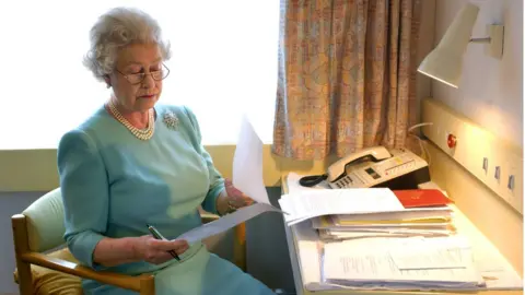 PA Media Queen Elizabeth II at work aboard the Royal train near Darlington on 7 May 2002