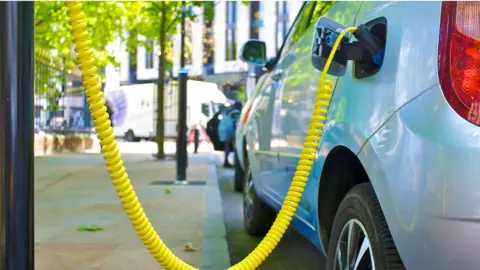 Getty Images Electric car charging on the street