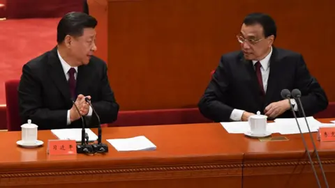 Getty Images China's President Xi Jinping (L) talks with Premier Li Keqiang during a celebration meeting marking the 40th anniversary of China's "reform and opening up" policy at the Great Hall of the People in Beijing on December 18, 2018.