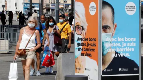 Reuters People wearing protective face masks walk near the Old Port (Vieux Port) in Marseille, France