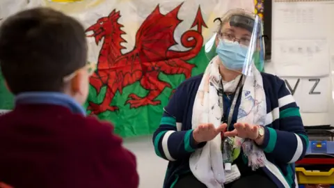 Getty Images A teacher delivering a lesson in PPE