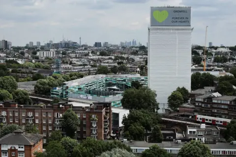 Getty Images A sign with "Grenfell Forever In Our Hearts" is displayed on the top of Grenfell Tower