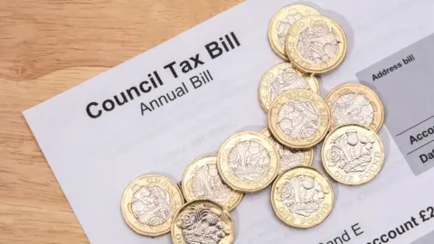 Getty Images A council tax bill with pound coins on it