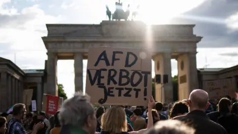 EPA A protester holds a placard reading "AfD ban now!' during a rally in Berlin, 5 May 2024.