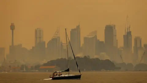 EPA Smoke haze from bushfires turns the sky orange and obscures buildings in Sydney's skyline