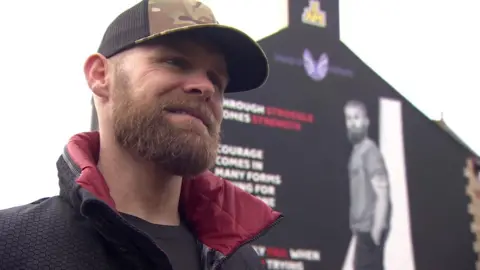 Mark Ormrod stood in front of the mural