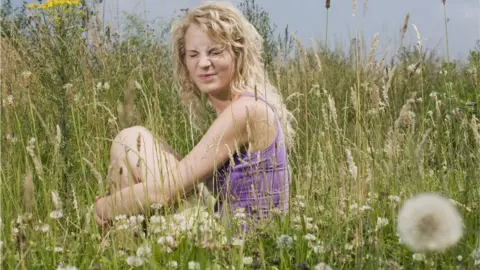 Getty Images Woman sitting in grass