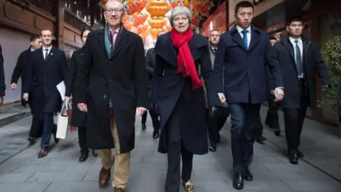 PA Prime Minister Theresa May and her husband Philip walk through a market after visiting the Yu Yuan Temple Garden in Shanghai