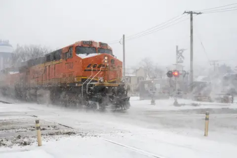 Stephen Chung / Alamy Stock Photo A freight train passes as heavy snowfall begins in a western suburb of Chicago as a winter storm arrives in the Midwest.