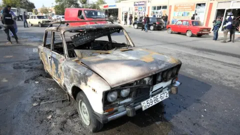 Reuters A burnt car, which was hit by shelling during a military conflict over the breakaway region of Nagorno-Karabakh, in the town of Barda, 28 October 2020