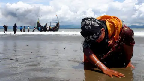 Reuters An exhausted Rohingya refugee woman touches the shore - September 2017