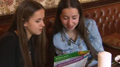 BBC Cerys and Cadi Davage holding a menu