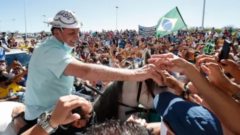 EPA A handout photo made available by the Brazilian presidency in which Brazilian President Jair Bolsonaro is received by hundreds of people on a visit to the city of Sao Raimundo Nonato