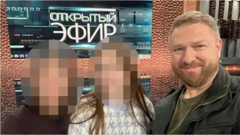 Telegram Alexander Malkevich next to two underage reporters, whose faces are blurred