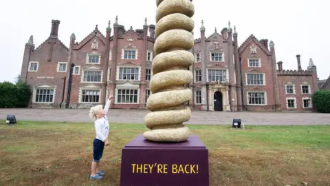 PA Media Three year-old Reign Thornton and a statue of a Turkey Twizzler