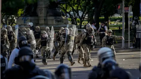 Getty Images National Guard troops are seen moving behind the US Park Police