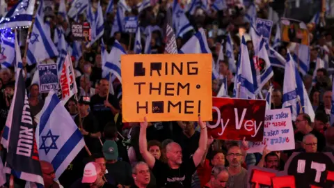 Reuters Dozens of protesters waving Israeli flags and placards in Tel Aviv calling for hostages to be returned home