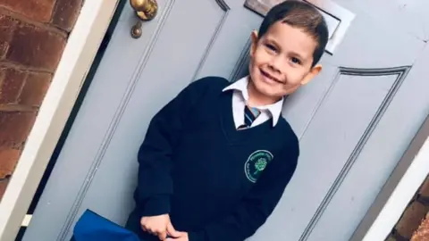 Hand in Hand for Oscar Oscar Saxelby-Lee in his school uniform