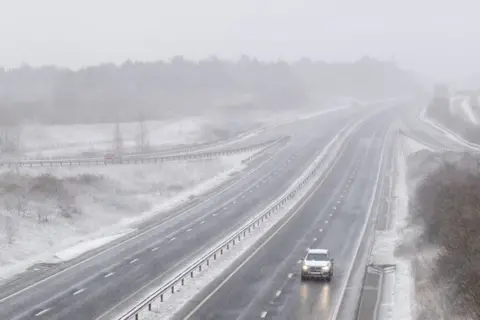 PA Media Snow falls on the A14 near Stowmarket, in Suffolk, on 7 February 2021