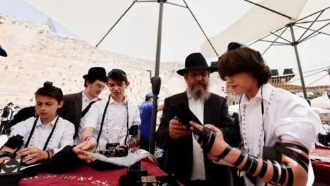 Reuters Tima Kobakov, a 13-year-old Jewish refugee from Ukraine celebrates his bar mitzvah at the Western Wall in Jerusalem's Old City (11 April 2022)