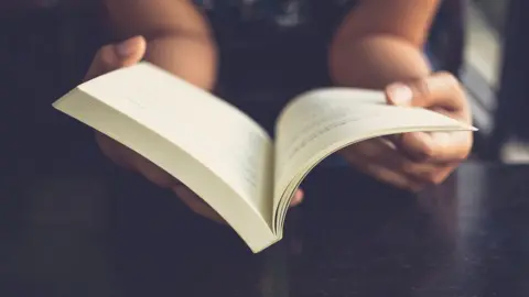 iStock Person reading book