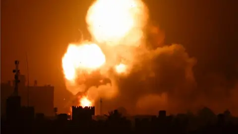 Reuters Flames and smoke rise following Israeli air strikes in the southern Gaza Strip (19 April 2022)