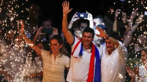 Reuters Santiago Peña (centre) celebrates at the Colorado Party headquarters in Asunción, Paraguay. Photo: 30 April 2023