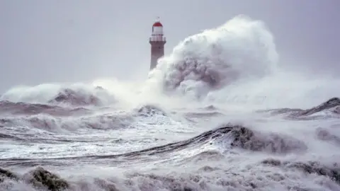 PA Media Big waves break over sea wall at Roker