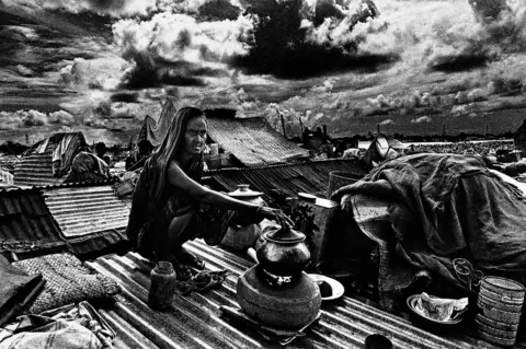 Shahidul Alam Woman cooking on rooftop, Jinjira, Dhaka, Bangladesh. 1988.