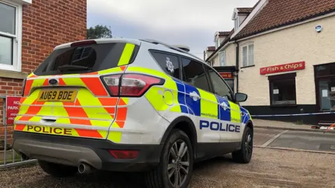 Steve Silk/BBC  Police car at the scene in Loddon.