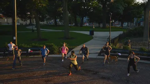 The Washington Post via Getty Images People exercise in Washington Park in the Over-The-Rhine neighborhood