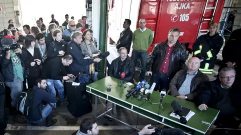 BALINT PORNECZI/AFP Hungarian Prime Minister Viktor Orban (standing 3R) listens to a journalist's question at the fire station headquarters in Ajka, 140km (87 miles) west of Budapest on 9 October 2010